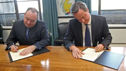 PA Media Prime Minister David Cameron (right) and Scotland's First Minister Alex Salmond (left), sign a referendum agreement, during a meeting at St Andrews House in Edinburgh.