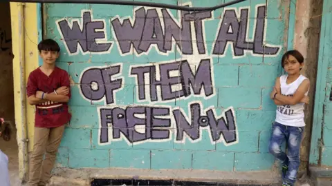 Salim Mudar Salim Mudar painting in East Aleppo flanked by son and friend