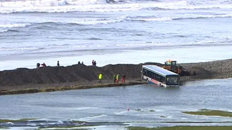 A bus lies partially submerged in water after Newgale is battered by storms in 2014