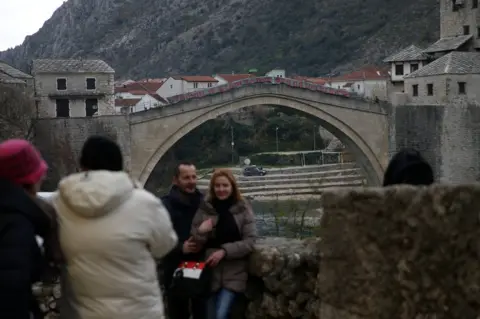 Reuters People take pictures in front of Mostar's Old Bridge