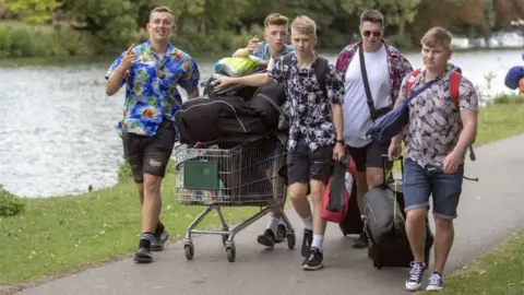 PA Young men with a trolley of camping kit