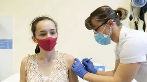 EPA A medical worker administers the Sputnik V vaccine to a young woman in Hungary, 13 April 2021