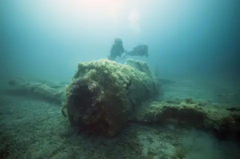 AFP A French military diver member of the FS Pluton M622 navy de-mining ship, swims on July 2, 2018, above the wreck of an USAAF P-47 Thunderbolt (Warthog) US fighter plane