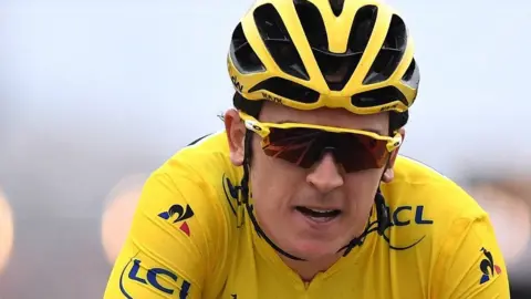 Getty Images Geraint Thomas in action wearing a yellow crash helmet and sunglasses