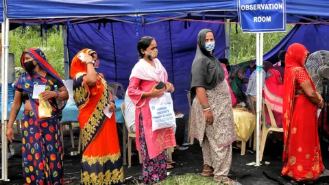 Getty Images People waiting to get vaccinated against Covid-19 at a camp in Rajghat, on 15 September 2021 in New Delhi, India