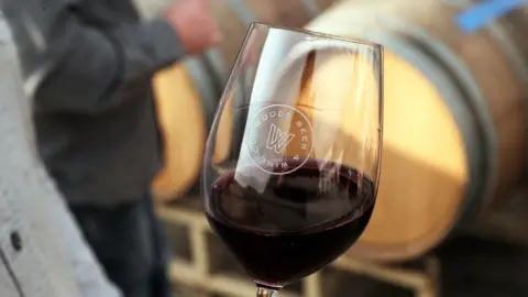 Getty Images A man holding a class of Californian red wine at a bar in San Francisco