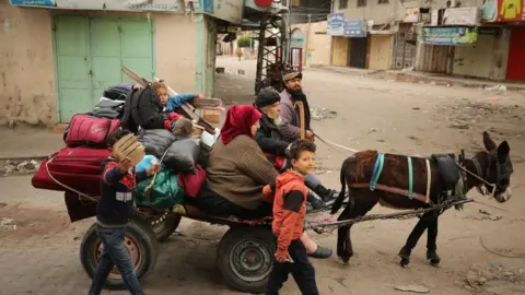 Anadolu Displaced Palestinians leave the area near al-Shifa Hospital, in Gaza City (18 March 2024)