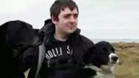 family photo Iwan Caudy with his two dogs on the beach