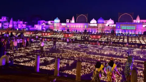 Getty Images Devotees light earthen lamps on the banks of river Sarayu on the eve of Diwali, the Hindu festival of lights, in Ayodhya on October 23, 2022. (Photo by SANJAY KANOJIA / AFP) (Photo by SANJAY KANOJIA/AFP via Getty Images)
