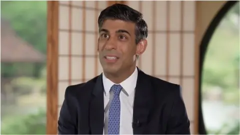 Rishi Sunak sitting for an interview in Japan