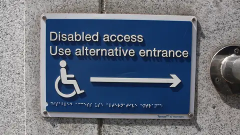 Laurence Coss / BBC Disabled access notice in Braille to use alternative entrance