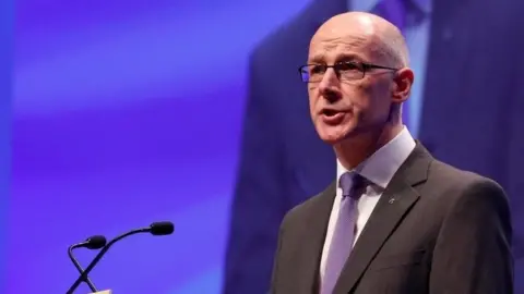 Reuters John Swinney speaking at the conference