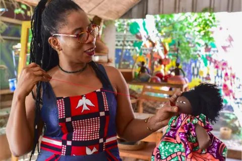 AFP The Burkinabe artist and doll designer Mare Abibou sews up one of her creations as she stands in her workshop in Ouagadougou on October 27, 2018.