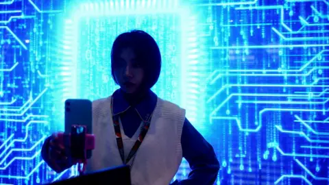 Reuters woman holding phone with blue technology in background