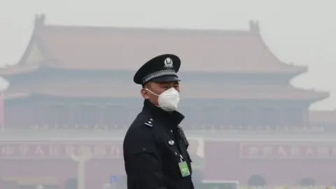 Reuters An officer wears a mask in Beijing