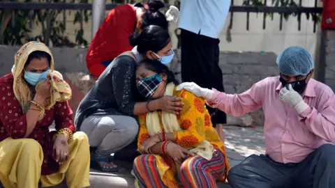 Getty Images Grieving relatives and family members of Covid victims wait outside Maulana Azad Medical College mortuary to collect their bodies, on April 25, 2021 in New Delhi, India