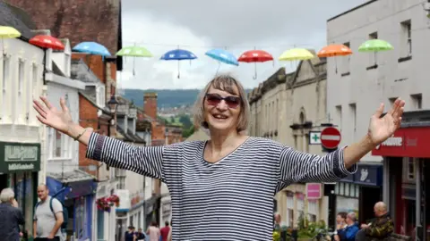 Simon Pizzey Jane Roberts stands under the neurodiversity umbrella project in the town of Stroud