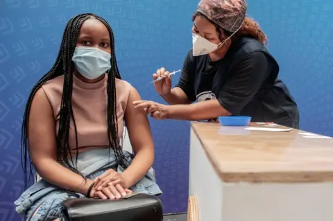 AFP A woman receives a dose of the Pfizer-BioNTech vaccine against Covid-19 in Sandton, Johannesburg, on 15 December 2021
