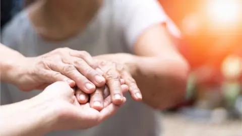 Getty Images A person holding another person's hand