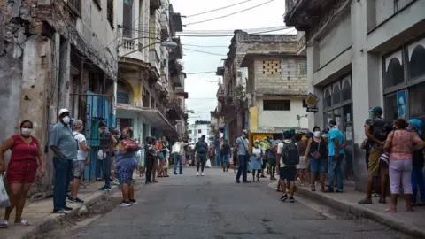 Getty Images People queue to buy food in Havana on 2 February