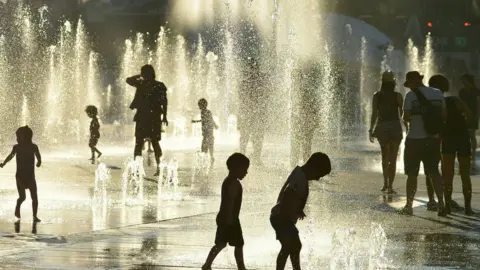 AFP Montreal children cool off at a water fountain in the midst of a deadly heat wave