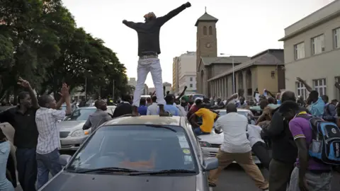 EPA Man on car in Harare