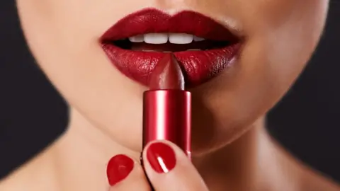 Getty Images A woman applying lipstick