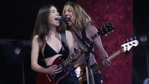 PA Media Haim performing on the Pyramid Stage during the Glastonbury Festival