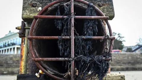 GLYN KIRK/AFP via Getty Images A photograph taken on March 30, 2023 shows a CSO (Combined Sewer Overflow) pipe on Ryde beach on the Isle of Wight which has suffered from sewage pollution in recent years caused by using a combined sewage overflow pipe