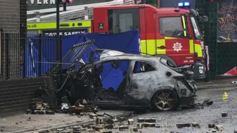 PA Media Burnt out car