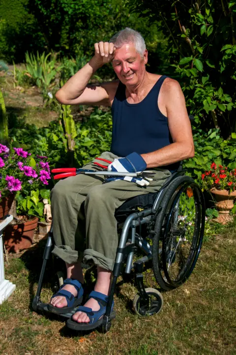 Shutterstock Man in wheelchair sweltering in a sunny garden