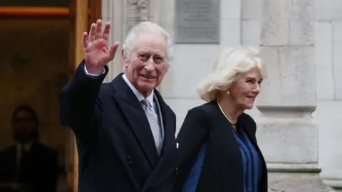 King Charles departing hospital with Queen Camilla