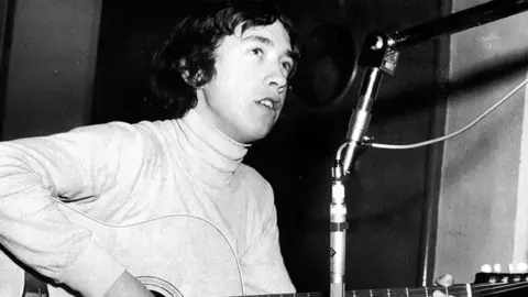 BBC George Young playing the guitar