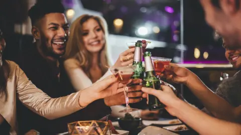 Getty Images Friends toasting the New Year