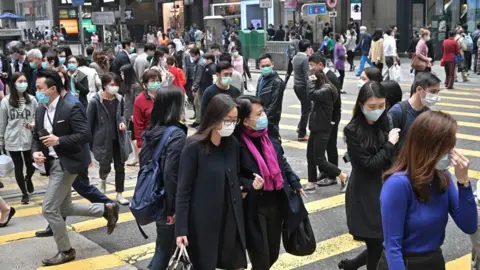 AFP Pedestrians wear face masks, as a precautionary measure against the COVID-19 coronavirus, in Hong Kong on March 12, 2020