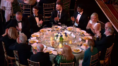 The leaders of the main Stormont parties and US delegates sit around a table at a gala dinner in Washington DC