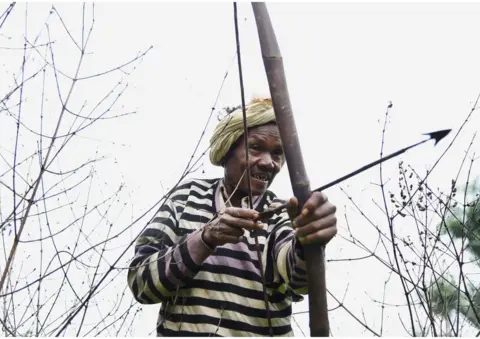 WaterAid/Ronny Sen A man uses his bow and arrow to hunt wild animals.