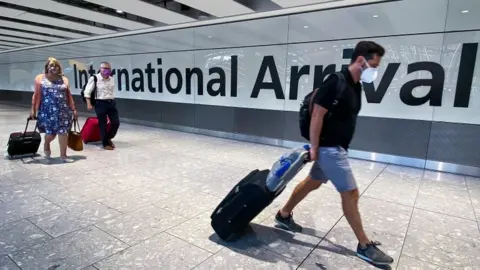 PA Media Passengers in the arrivals section of Heathrow Airport