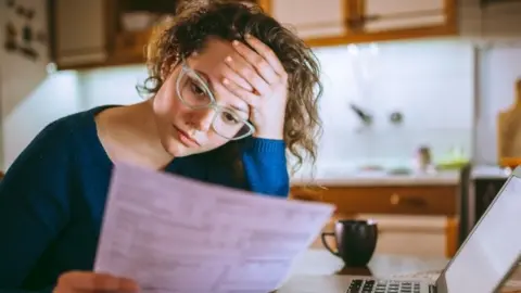 Getty Images Woman studies bill