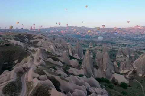 Behcet Alkan/Anadolu Agency/Getty Images) Hot air balloons glide over the historical Cappadocia region, located in Nevsehir province, Tukery on June 15, 2022.
