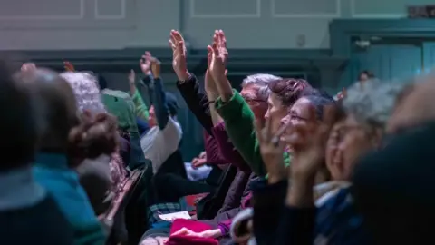 Gill Thomas, Mouse About Town photography A close up of the audience, some with raised hands
