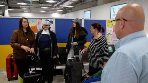 BBC A Ukrainian family arriving at London Luton Airport hub