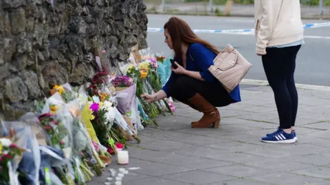 PA Media People leave flowers in the Keyham area of Plymouth where six people, including the offender, died of gunshot wounds in a firearms incident