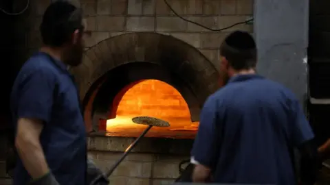 Reuters Orthodox Jewish men prepare matza, a traditional unleavened bread eaten during the upcoming Jewish holiday of Passover, at a bakery in Kfar Chabad, Israel, April 18, 2024.