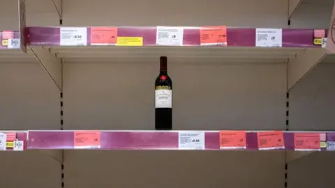 Getty Images Bottle of wine on an empty supermarket shelf