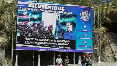 Getty Images A poster of President Nicolas Maduro and security forces at the entrance of El Helicoide jail in Caracas