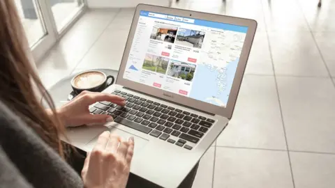 Holidu A woman looking at Holidu's website