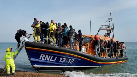 PA Media A boat carrying people thought to be migrants arrives in Dungeness, Kent in September