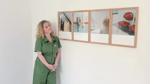 Cíara Hillyer Cíara Hillyer standing beside her final project portfolio titled 'Breathing Space' picturing moments inside a hospital