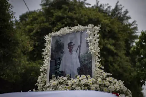 Getty Images A photo of Kian Delos Santos, 17, on top of the hearse during his funeral in Caloocan city, Philippines, 26 August